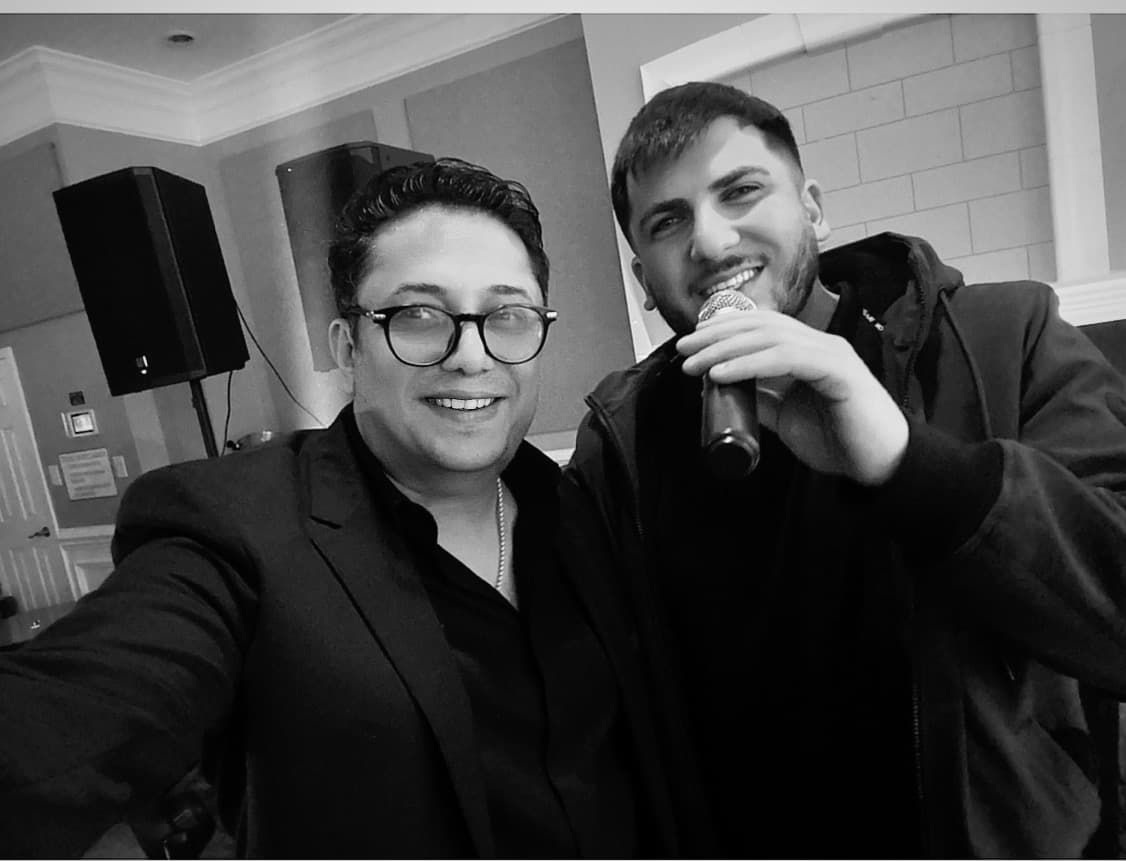 Lazar beside a singer holding a microphone